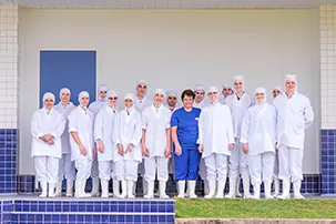 Equipe Fricéu uniformizada em frente à fábrica